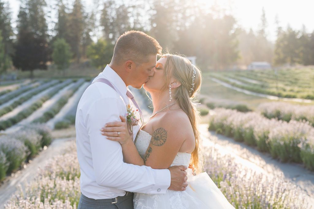 Bride and groom kissing at a garden wedding venue near Spokane with outdoor wedding ceremony & mountain views