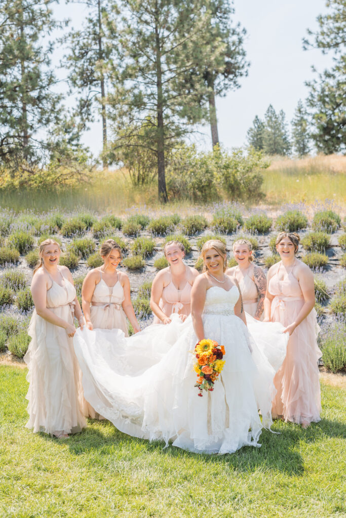 Bride and bridesmaids pose for wedding day photos at the outdoor wedding ceremony near Spokane