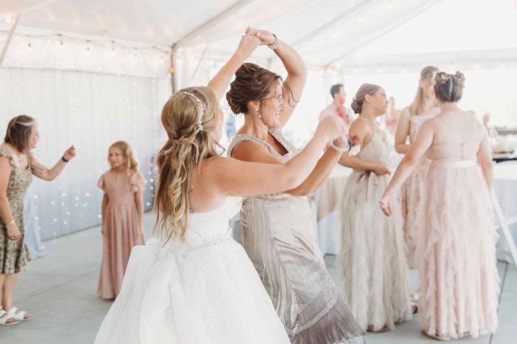 What Happens If It Rains on Your Wedding Day? 6 Bride & Bridesmaids dancing at a spring wedding reception in pink bridesmaid dresses at a garden wedding near Spokane