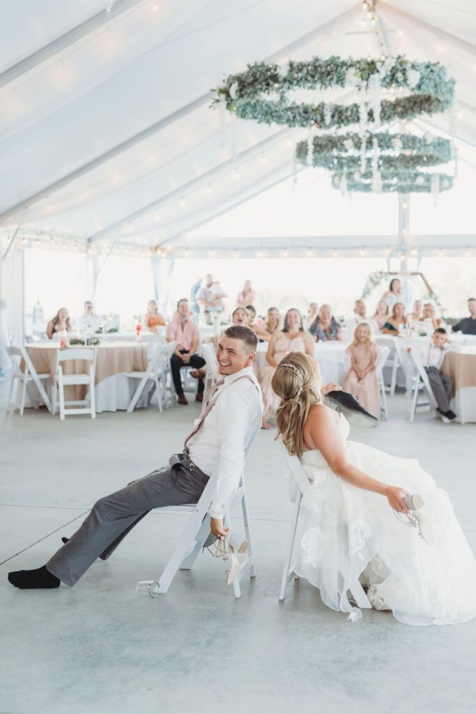 When Should You Create Your Wedding Website? 5 Bride and Groom playing the Shoe Game during a wedding reception near Spokane